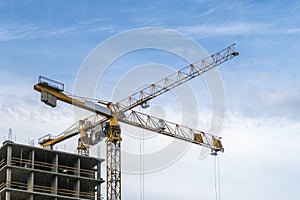 Building construction site. 2 yellow tower cranes against blue sky