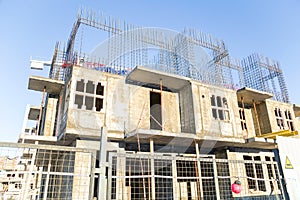 Building construction site behind a fence against blue sky