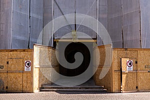 Building at a construction site covered with fabric and scaffolding in the city