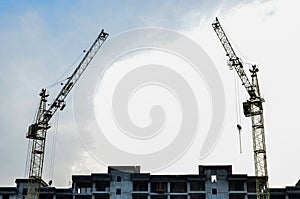 Building construction site with crane against bright blue sky.