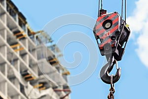 Building construction site - crane hook against blue sky