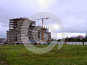 Building construction site. Large construction crane. Construction workers working on a huge building site.