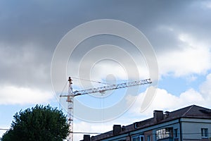 Building construction site with tower crane against blue sky