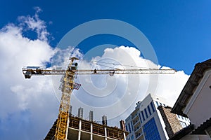 Building construction site with tower crane against blue sky