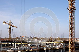 Building construction site with workers and cranes