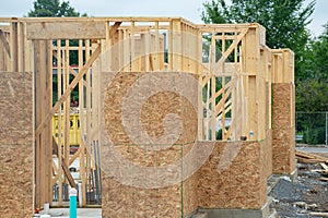 Building construction, wood framing new home under construction roof being built against blue sky