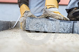 Building contractor laying a paving slab