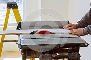 Building contractor worker using circular saw to cut boards on a new home constructiion project