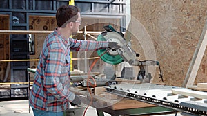 Building contractor worker using hand held worm drive circular saw to cut boards on a new home constructiion project