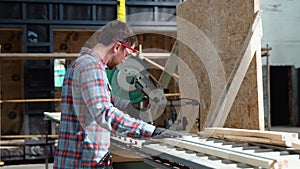 Building contractor worker using hand held worm drive circular saw to cut boards on a new home constructiion project
