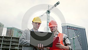 Building contractors using portable computer during site inspection