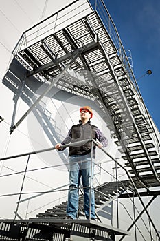 Building control inspector standing on metal staircase