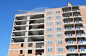 Building crane and building under construction with red brick walls