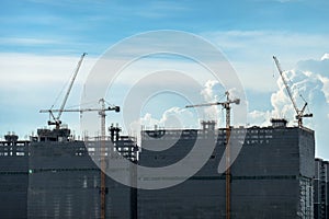 Building crane and buildings under construction and cloudy sky