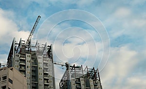 Building crane and buildings under construction and cloudy sky,copy space