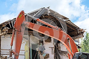 Building demolition with hydraulic excavator. dismantling an old