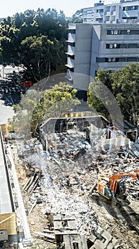 Building demolition site with an orange tractor beside