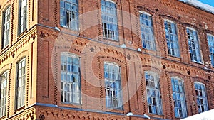 The building is in disrepair in the city. Broken glass in large windows