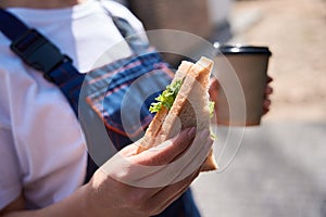 Building engineer has lunch break, eating sandwich and drinking coffee