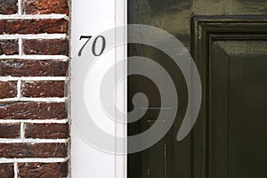 Building entrance with dark brick wall and house number in Amsterdam