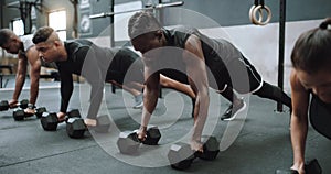 Building excellent upper body strength. a group of sporty young people exercising with dumbbells in a gym.