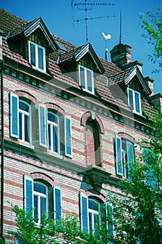 Old well-kept house with brick wall and shutters photo