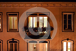 Building facade with illuminated apartment window photo