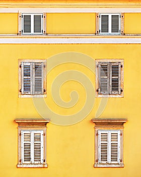 Building facade and old windows with classic wooden shutters blinds