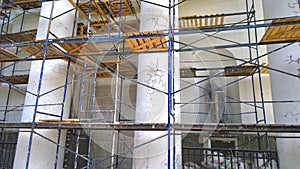 Building facade renovation, scaffolding. Restoration of an old ancient temple. Reconstruction. Revival of architecture. Grunged su photo