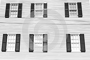 Building facade with white wooden wall, windows and blue shutters in key west, usa. Architecture and design. House front