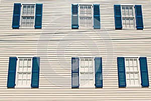 Building facade with white wooden wall, windows and blue shutters in key west, usa. Architecture and design. House front