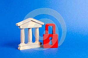 Building figurine with pillars in antique style and red padlock. Ineffective government, seizure of property and liquidation