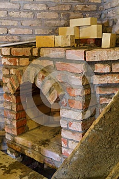 Building a fireplace in a house using old bricks. Beautiful bricklaying