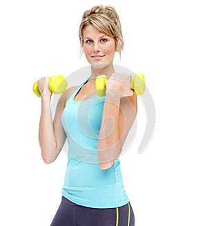 Building her strength. Attractive young woman in sportswear lifting dumbbells while isolated on white.