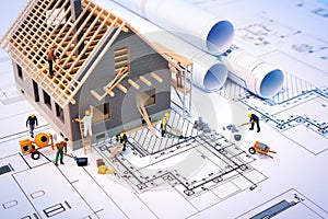 Building house on blueprints with worker photo