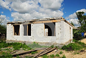 Building House Wall from Autoclaved Aerated Concrete Blocks with concrete lintel and Unfinished Roofing Construction.