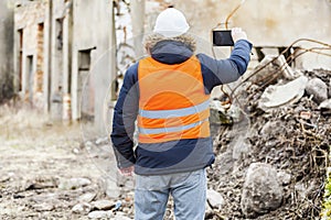 Building inspector filmed with tablet PC dilapidated building