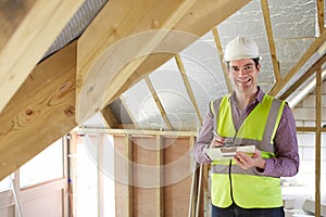 Building Inspector Looking At Roof Of New Property