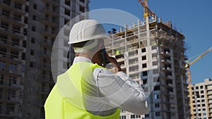 Building inspector making call at construction site