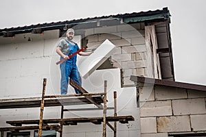 Building insulation saves energy. Master with styrofoam and level. Building facade