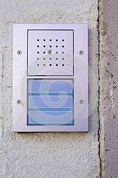 building intercom with 3 buttons and a speaker in chrome metal