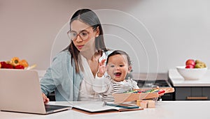 Building a life for the two of us. Shot of a young mother working from home while holding her baby.