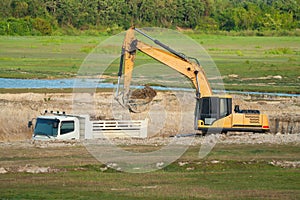 Building Machines: Digger loading trucks with soil