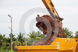 Building Machines: Digger loading trucks with soil. Excavator loading sand into a dump truck.