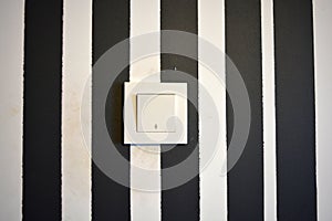 Building materials and accessories, white plastic switch and light switch located on the wall in the room.