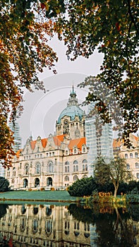 The building of the new city hall in the city of Hannover, Germany, peeping between the trees on an autumn day