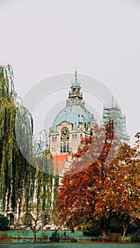 The building of the new city hall in the city of Hannover, Germany, peeping between the trees on an autumn day