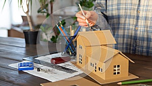 Building new home - design scale model of modern house. Real estate concept