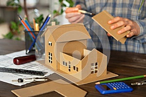 Building new home - design scale model of modern house. Real estate concept