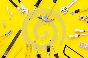 Building, painting and repair tools for house constructor work place set yellow background top view space for text